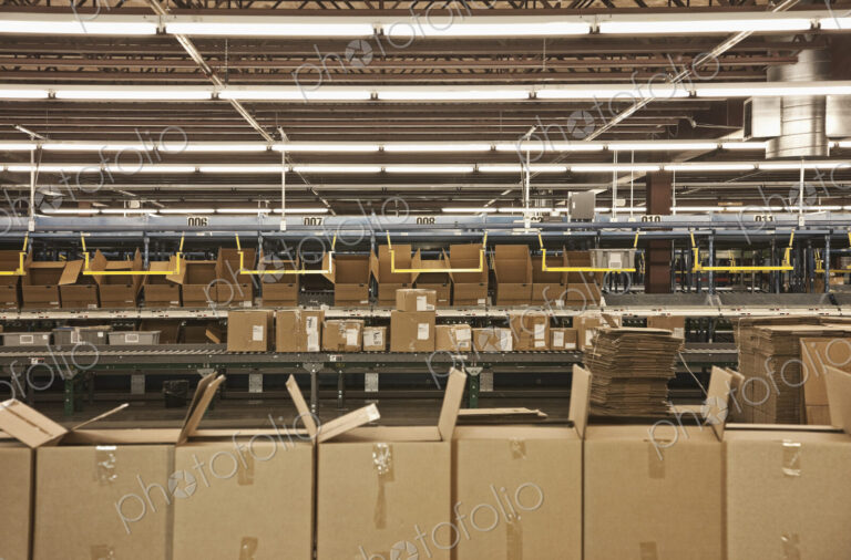 Cardboard boxes along production line in warehouse