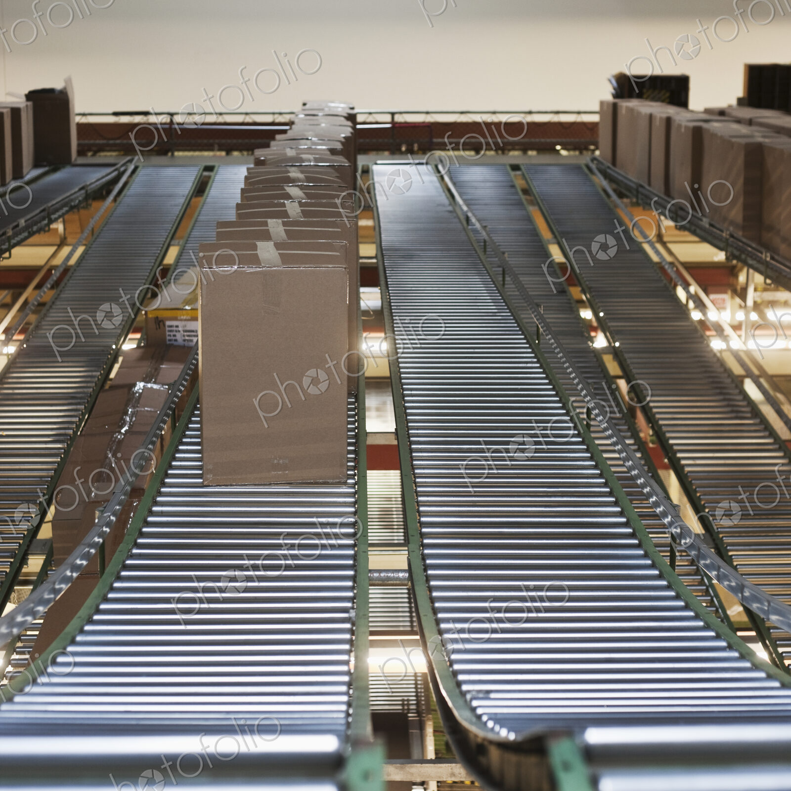 Cardboard boxes on conveyor belt in factory or warehouse.
