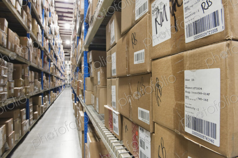 Cardboard boxes on tall shelves in warehouse.