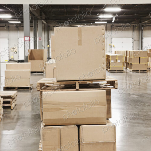 Cardboard boxes piled on pallets in warehouse. Cardboard boxes piled on pallets in warehouse.