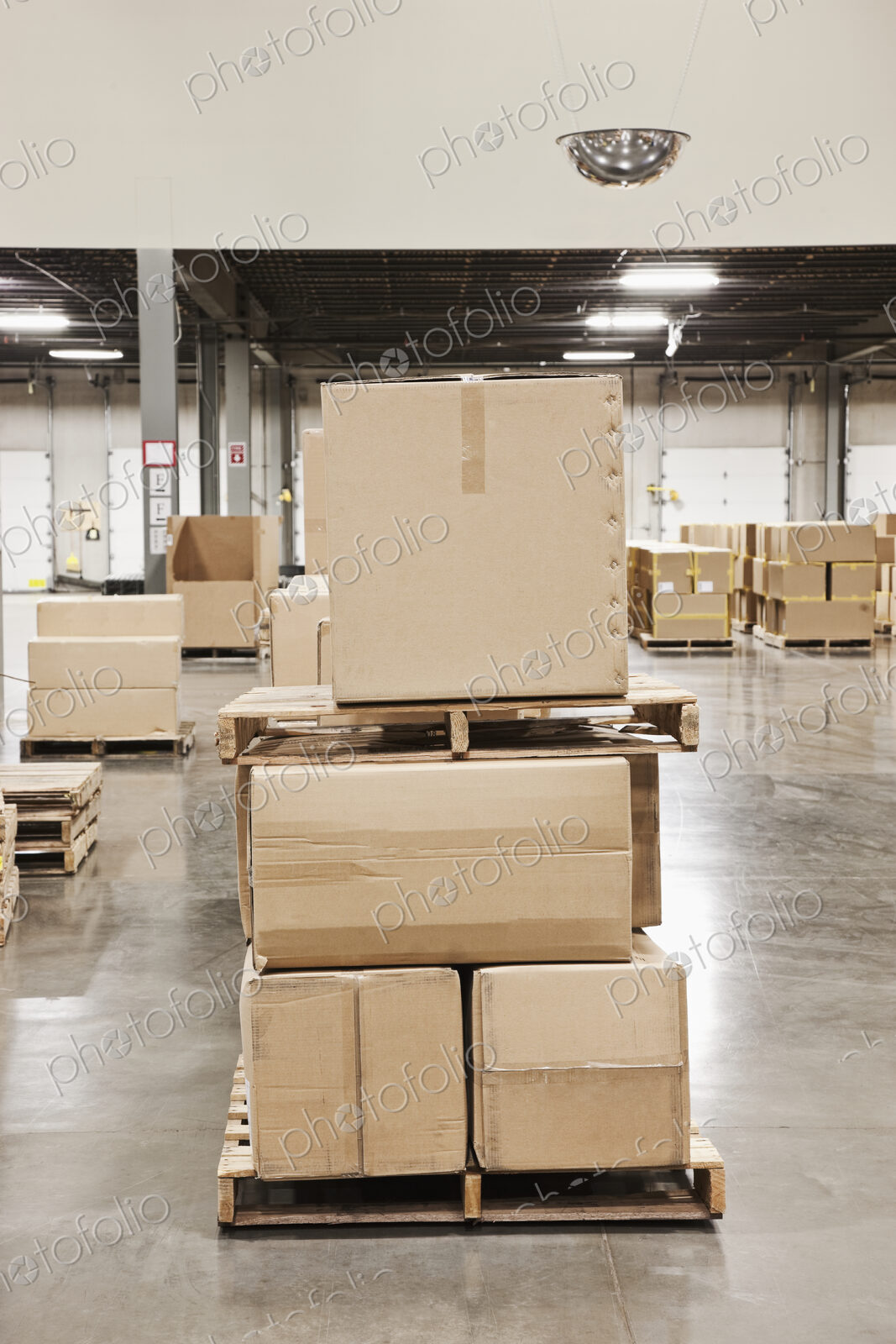 Cardboard boxes piled on pallets in warehouse.