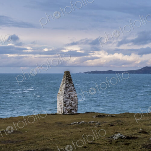 Cardigan Bay and stone cairn marking the entrance to Porthgain Harbour from the…