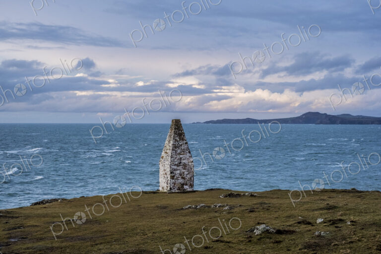 Cardigan Bay and stone cairn marking the entrance to Porthgain Harbour from the…