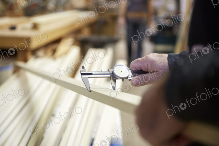 Carpenter measuring wood in workshop