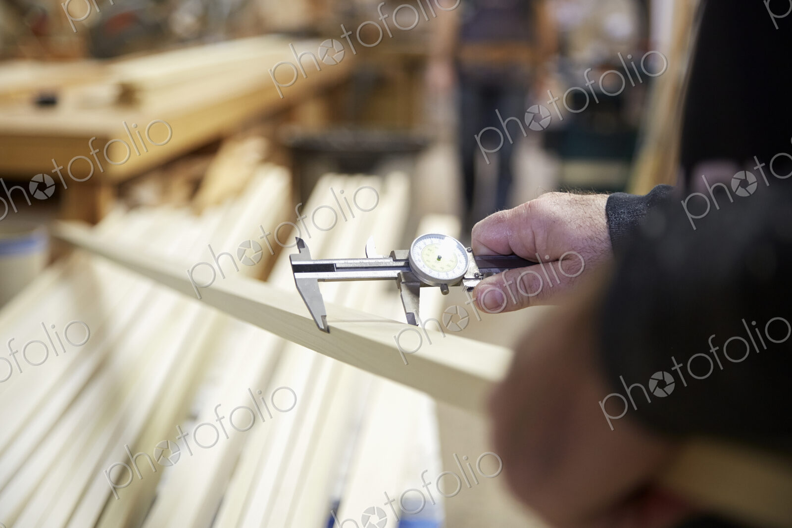 Carpenter measuring wood in workshop