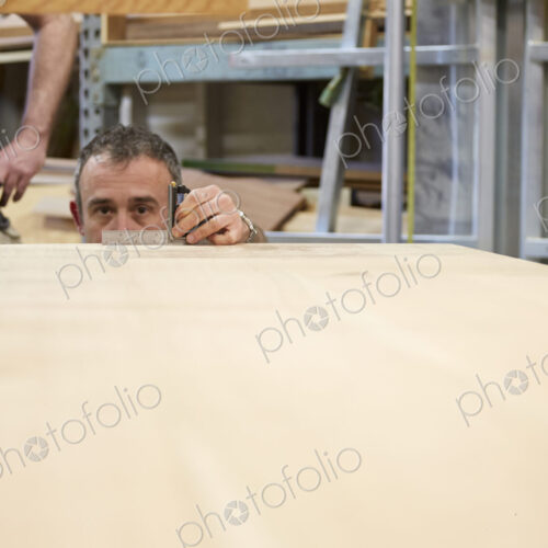 Carpenter measuring wood in workshop