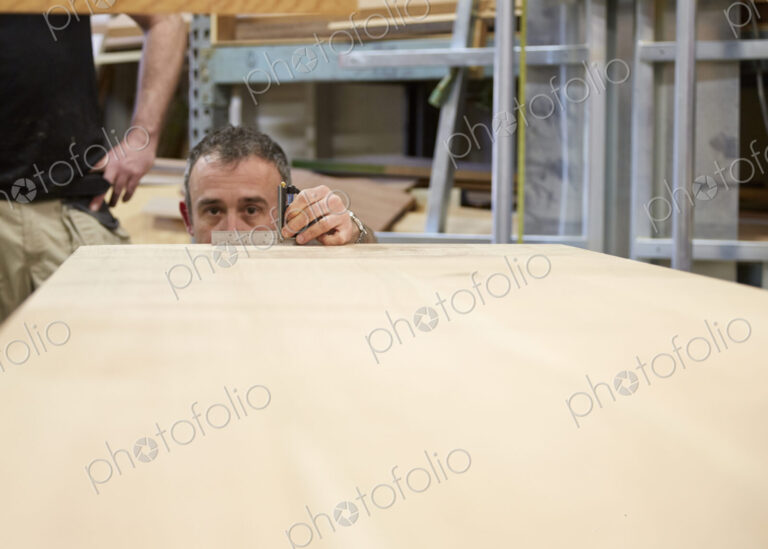 Carpenter measuring wood in workshop