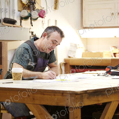 Carpenter sketching in workshop Carpenter sketching in workshop
