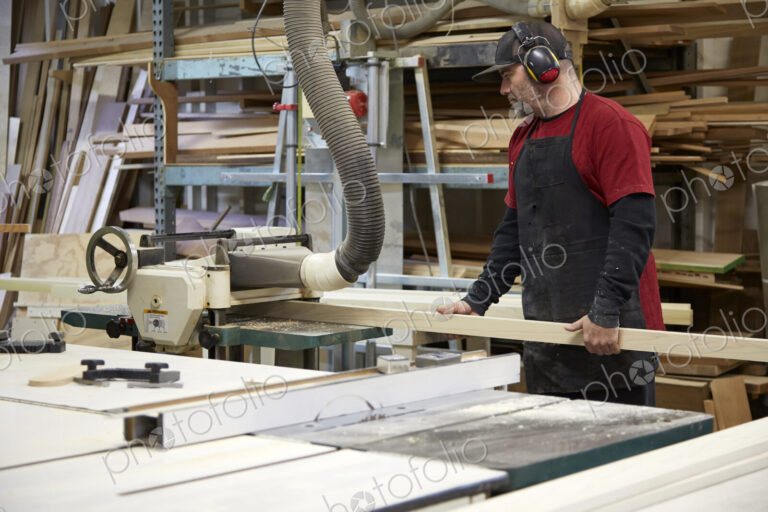 Carpenter using saw in workshop