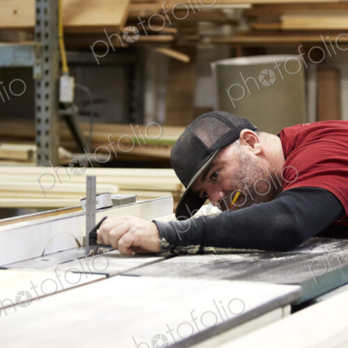Carpenter using table saw in workshop Carpenter using table saw in workshop