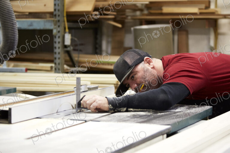 Carpenter using table saw in workshop