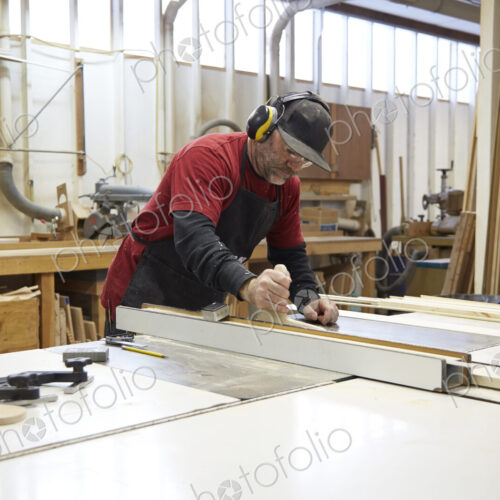 Carpenter using table saw in workshop Carpenter using table saw in workshop