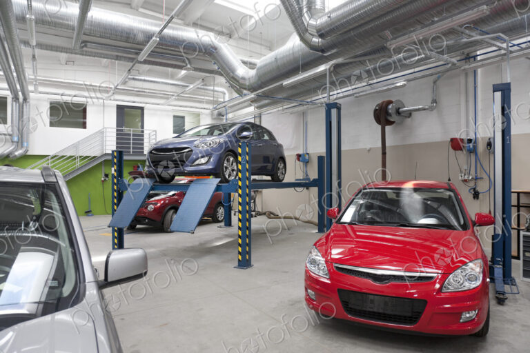 Cars in a large repair workshop or garage.