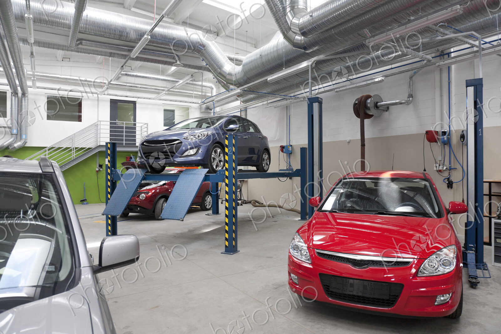 Cars in a large repair workshop or garage.