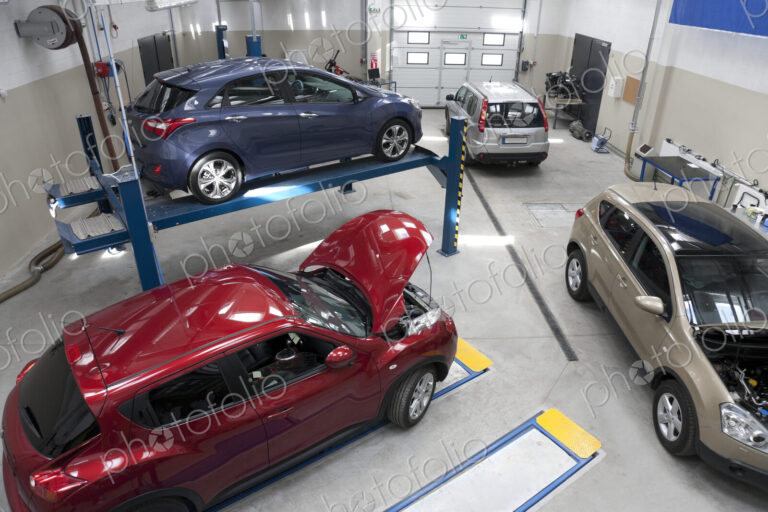 Cars in a large repair workshop or garage.