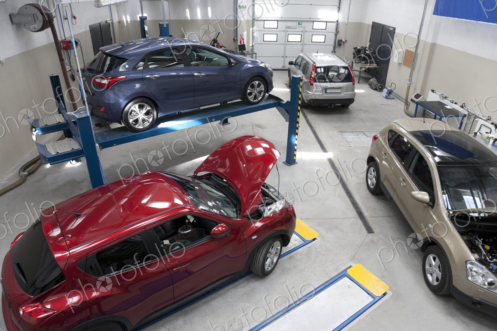 Cars in a large repair workshop or garage.