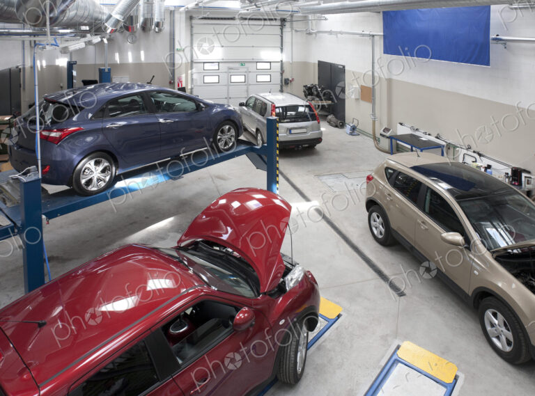 Cars in a large repair workshop or garage.