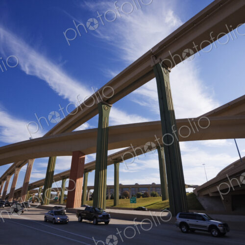 Cars on a highway with elevated roads above.