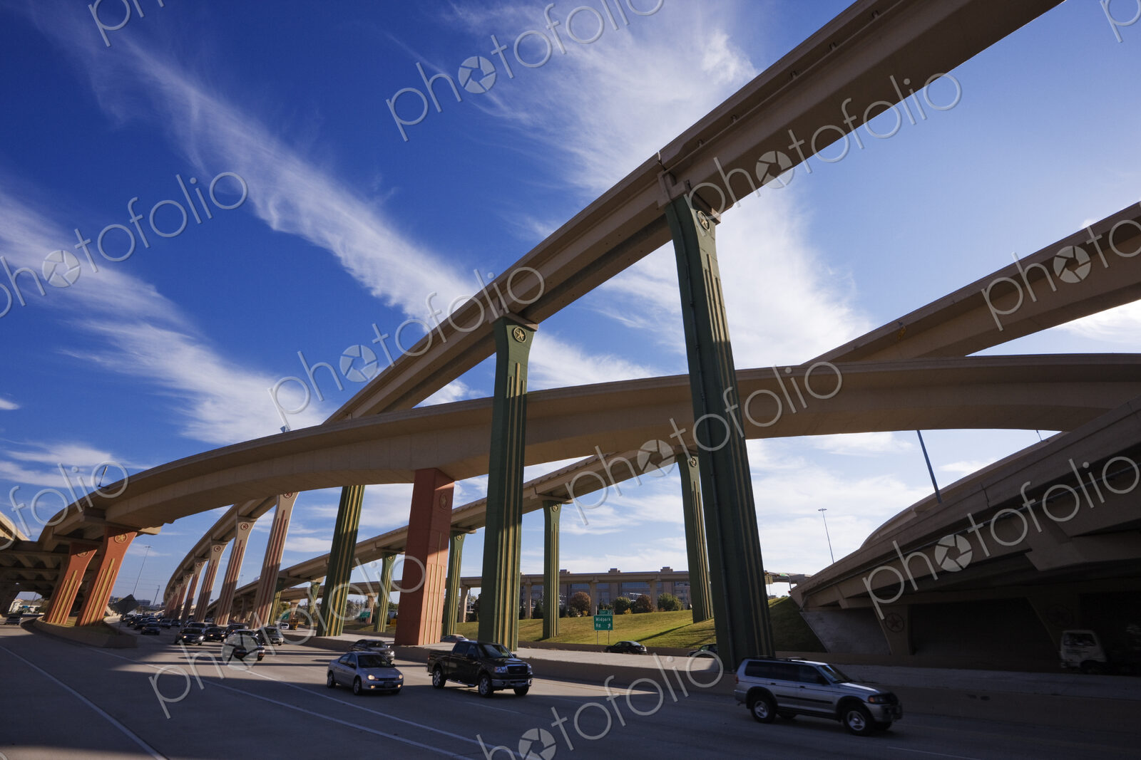 Cars on a highway with elevated roads above.