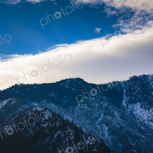 Cascade Mountains rising above Leavenworth, low cloud and a blue sky patch. Cascade Mountains rising above Leavenworth, low cloud and a blue sky patch.