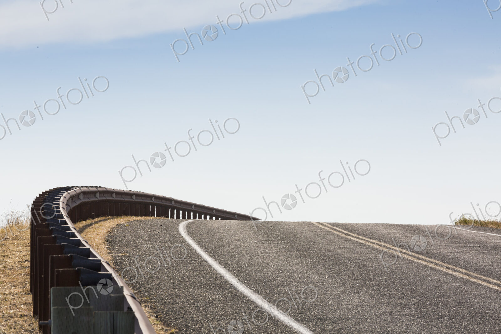 Cattle Pass Road, San Juan Island, a rising tarmac road curving around a bend.