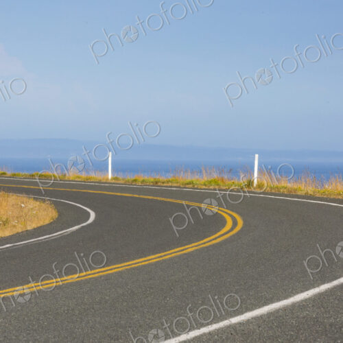 Cattle Pass Road, a curving road along the coast, view over the water.
