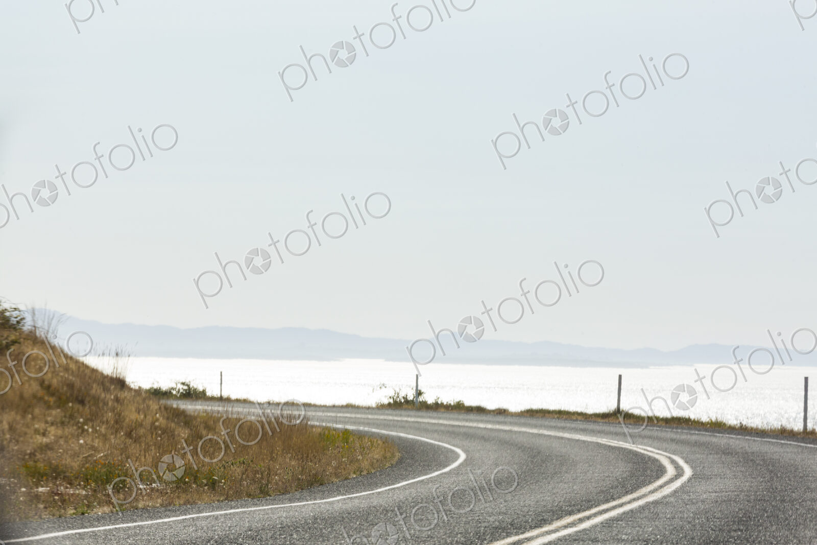 Cattle Pass Road, a curving road along the coast, view over the water.