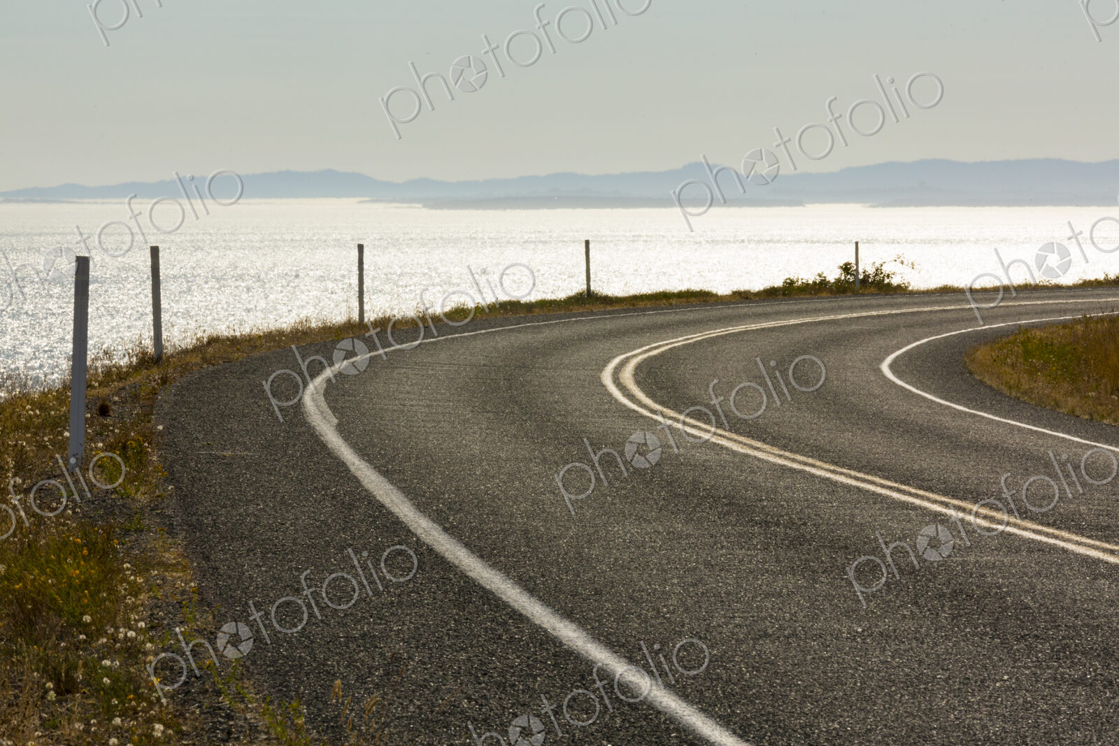 Cattle Pass Road, a curving road along the coast, view over the water.