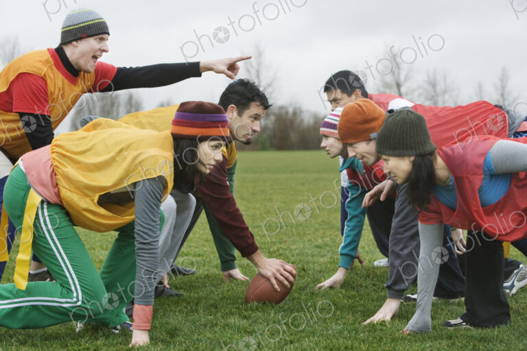 Caucasain man playing quarterback for an non-contact flag football team of friends.