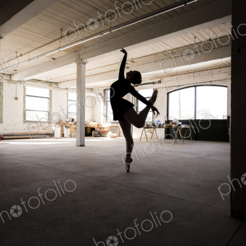 Caucasian ballet dancer performing in loft room Caucasian ballet dancer performing in loft room