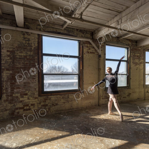 Caucasian ballet dancer performing in sunny loft Caucasian ballet dancer performing in sunny loft