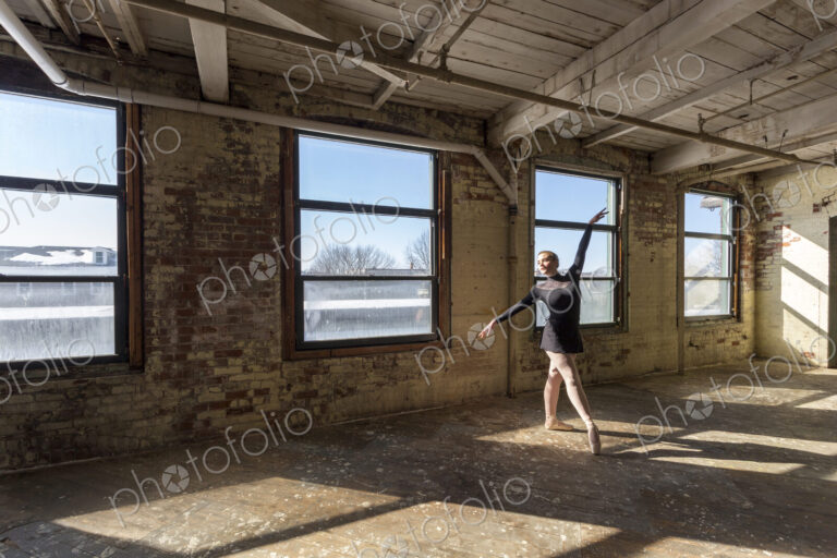 Caucasian ballet dancer performing in sunny loft