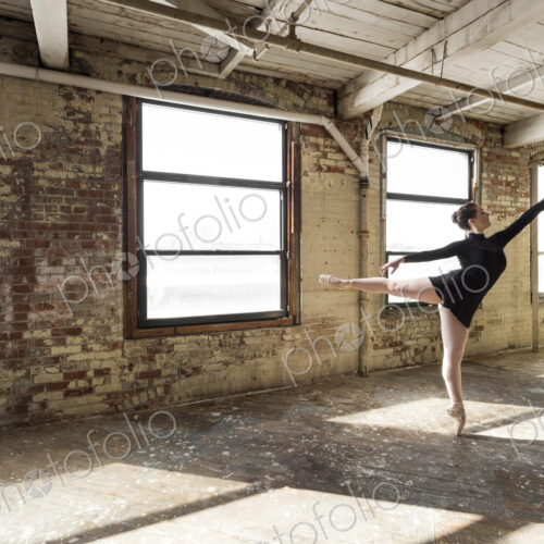 Caucasian ballet dancer performing in sunny loft room Caucasian ballet dancer performing in sunny loft room