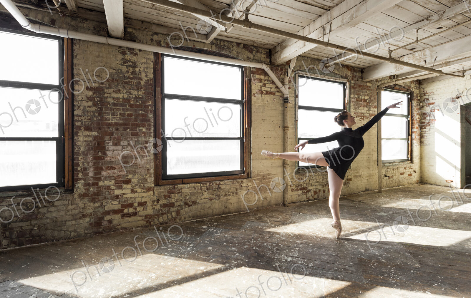Caucasian ballet dancer performing in sunny loft room