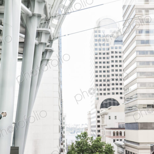 Caucasian business man standing on a balcony overlooking a cityscape.