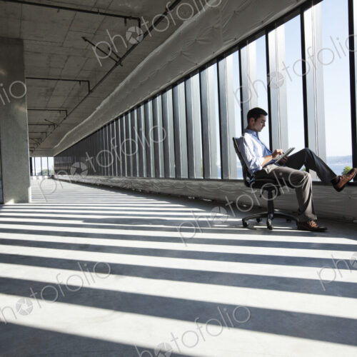 Caucasian business man working on a notebook computer while sitting a new empty raw…