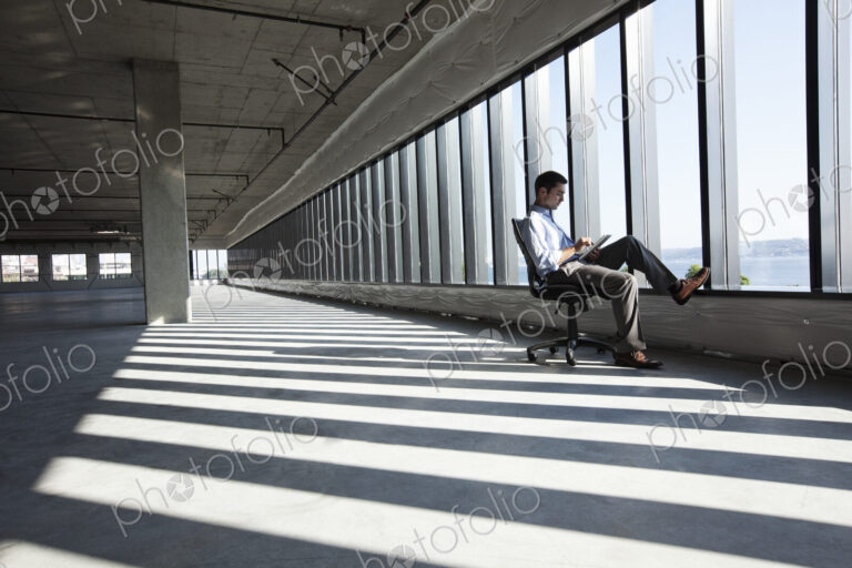 Caucasian business man working on a notebook computer while sitting a new empty raw…