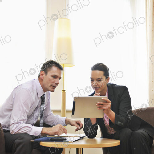 Caucasian business people using digital tablet in lounge Caucasian business people using digital tablet in lounge