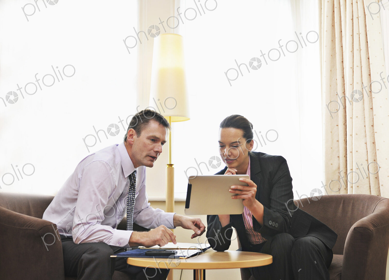 Caucasian business people using digital tablet in lounge