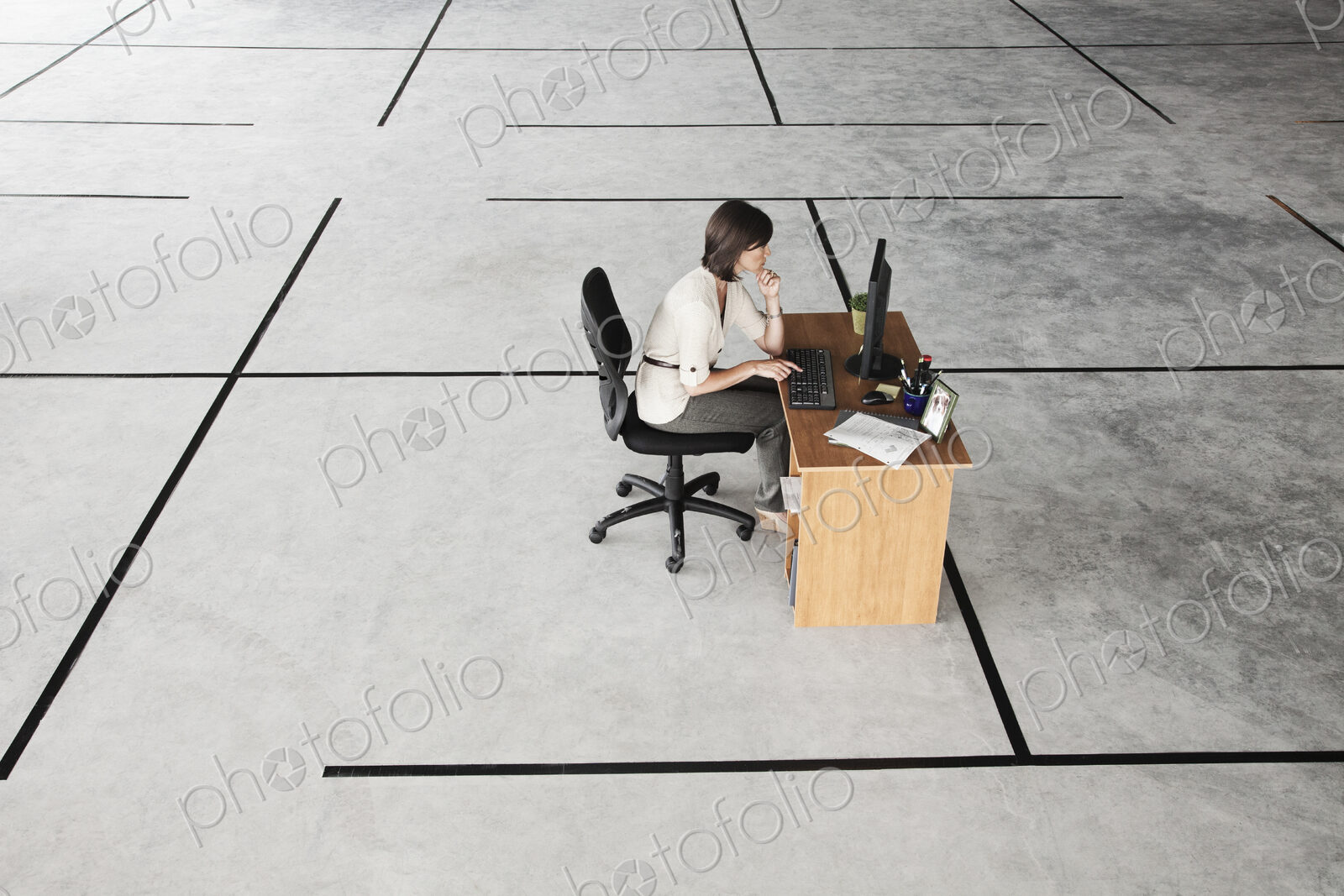Caucasian business woman at desk looking at a new office layout in a large empty raw…