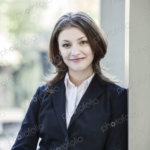 Caucasian business woman in a suit coat standing in an open lobby area. Caucasian business woman in a suit coat standing in an open lobby area.