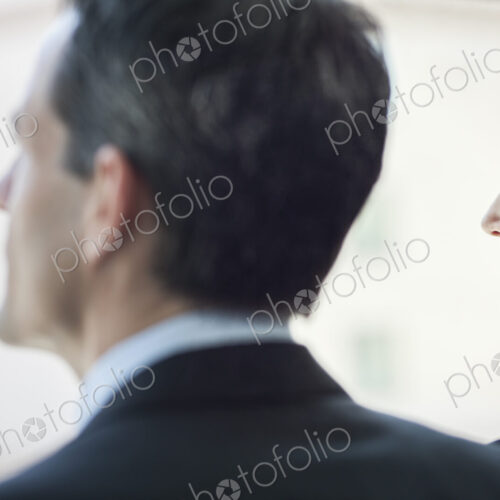 Caucasian business woman looking out the window of a conference centree lobby.