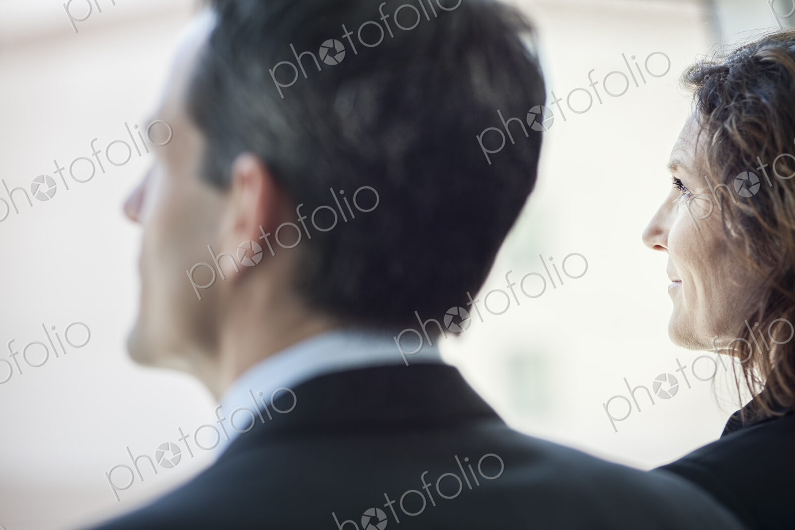 Caucasian business woman looking out the window of a conference centree lobby.