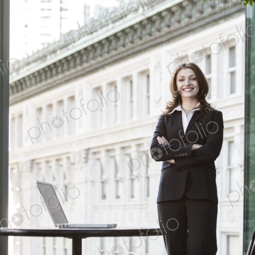 Caucasian business woman standing at a table in a lobby waiting area. Caucasian business woman standing at a table in a lobby waiting area.