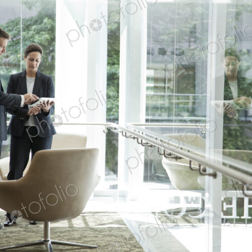 Caucasian businessman and woman meeting in a lobby area of a large business center. Caucasian businessman and woman meeting in a lobby area of a large business center.