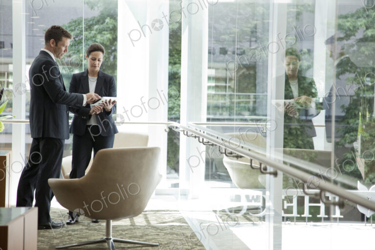 Caucasian businessman and woman meeting in a lobby area of a large business center.