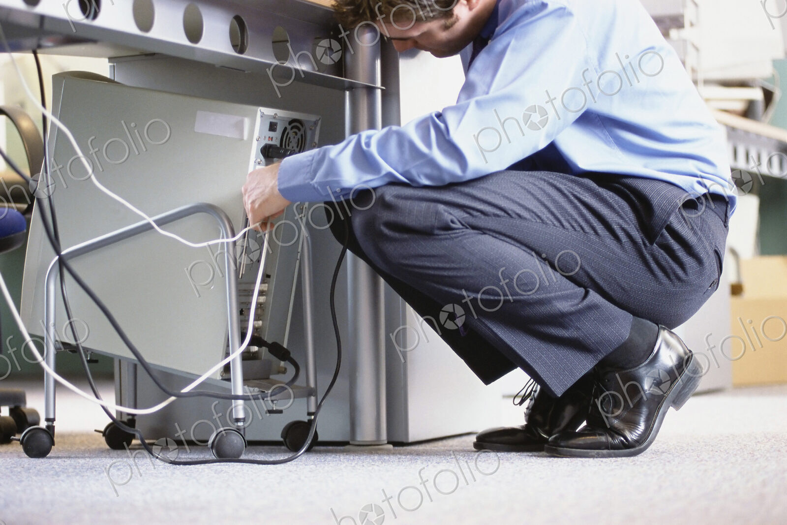 Caucasian businessman connecting cables to computer in office