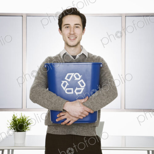 Caucasian businessman holding a recyle wast basket in his office. Caucasian businessman holding a recyle wast basket in his office.