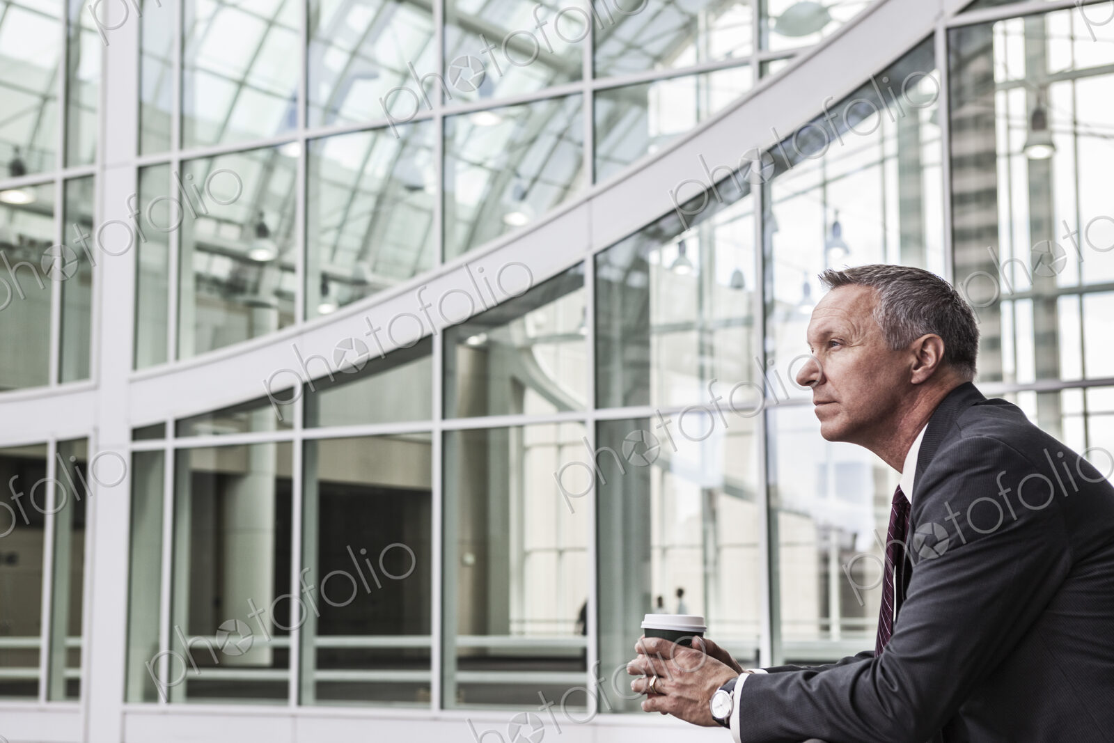 Caucasian businessman looking from a balcony near a covered walkway.