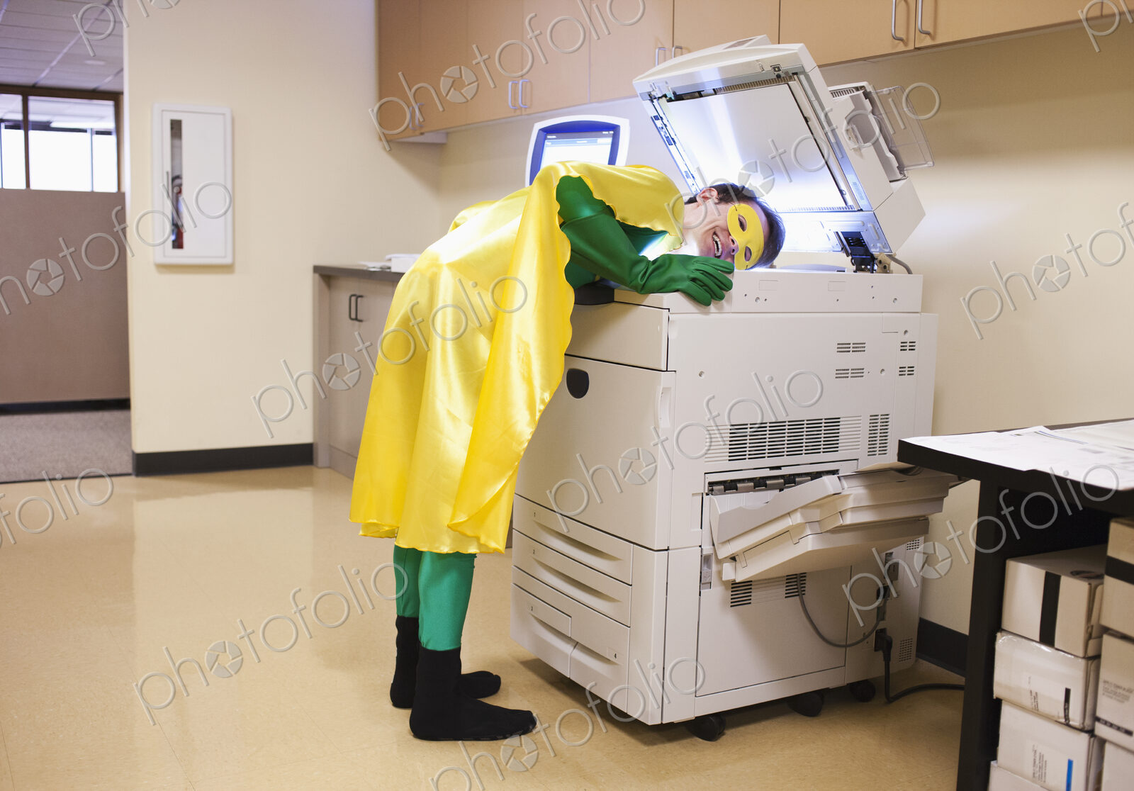 Caucasian businessman office super hero stands at photocopier, making copy of his head.